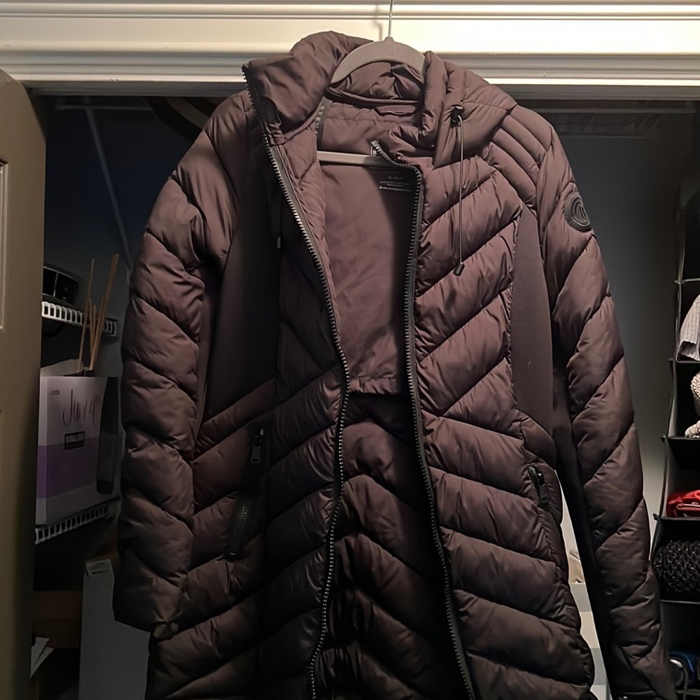 Puffy, long coat with hood …. Collapses into a backpack.